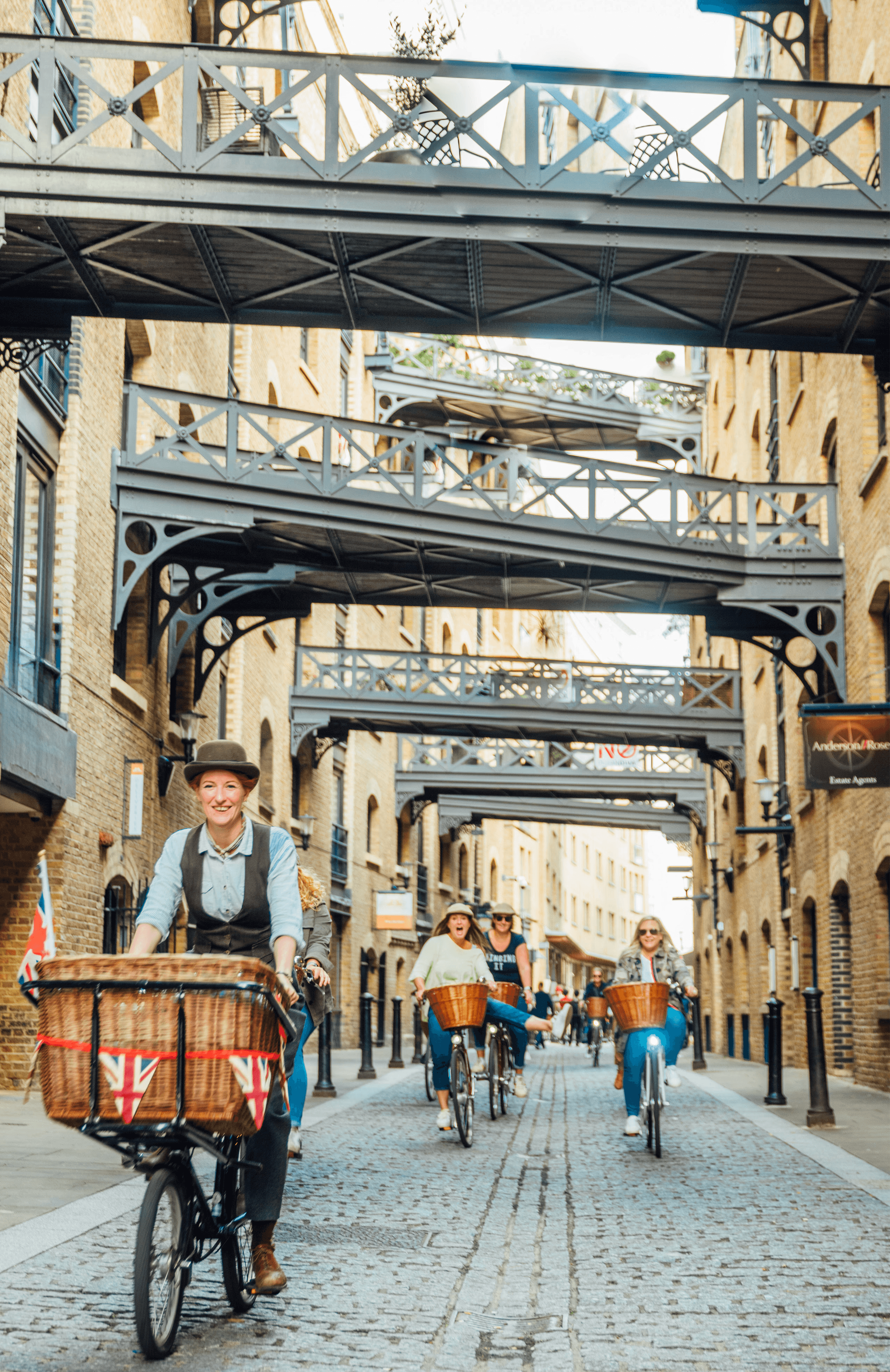 Vintage cyclists riding through Shad Thames in London 