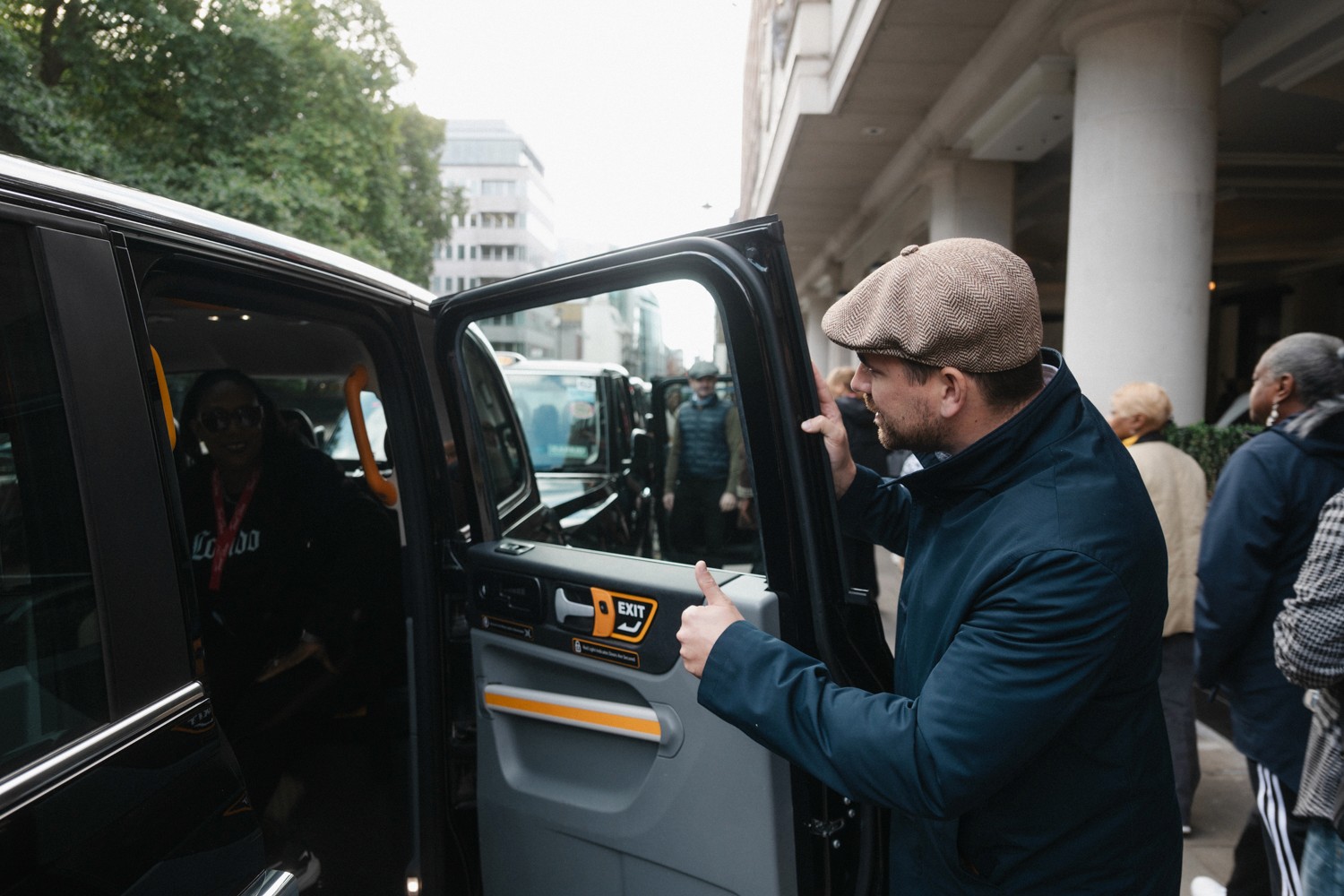 A tourist climbs into a classic London taxi for a sightseeing tour 