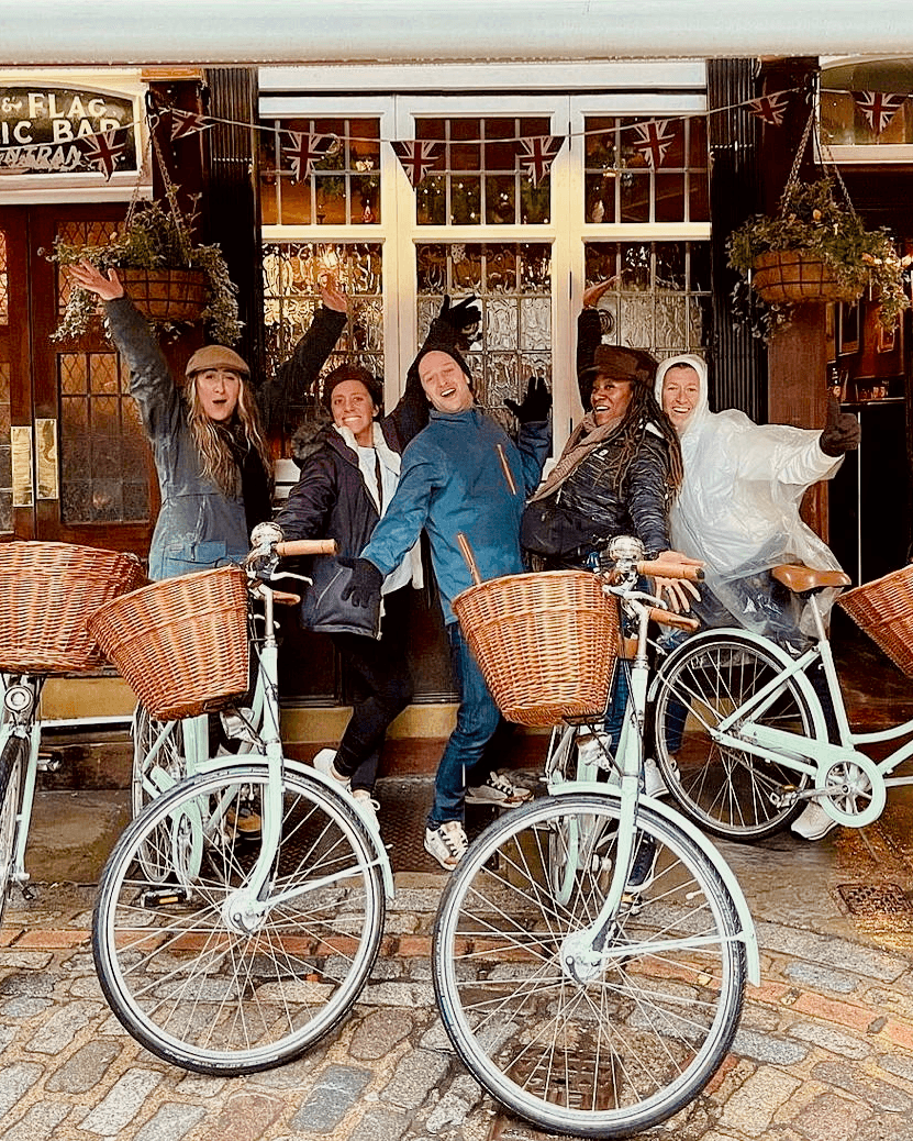 A rainy bike tour with happy smiling guests at the Lamb & Flag pub in Covent Garden 