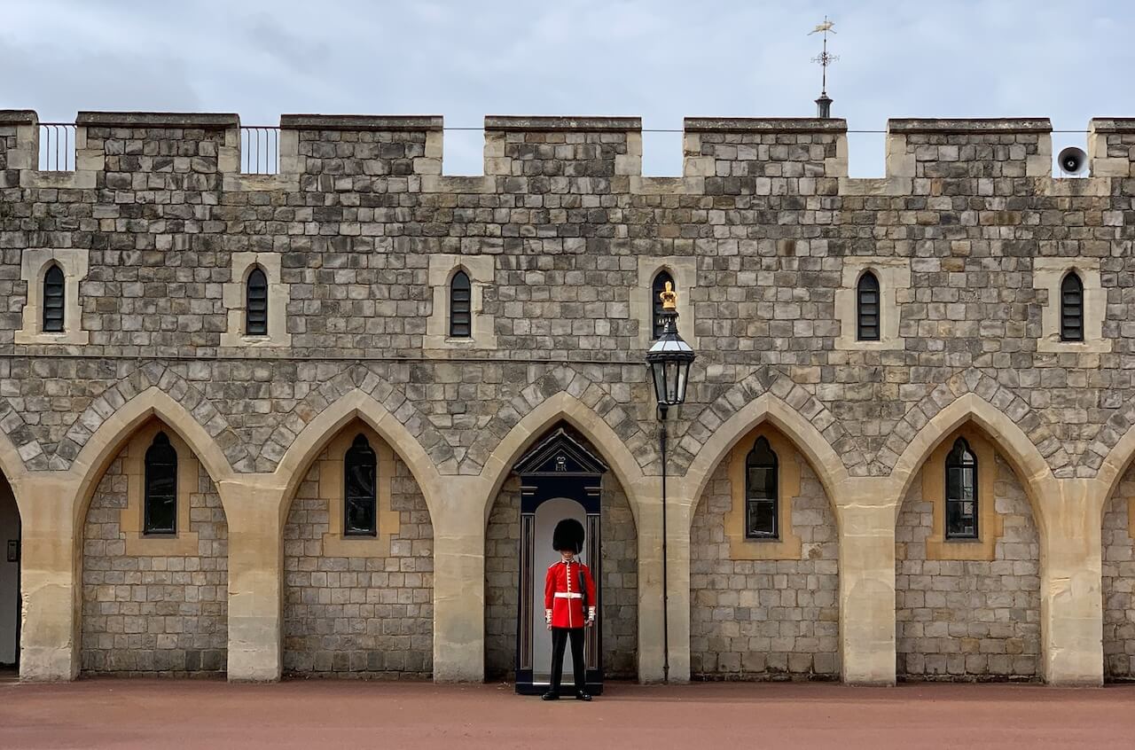 A Kings Guard in a red tunic on standing on Duty