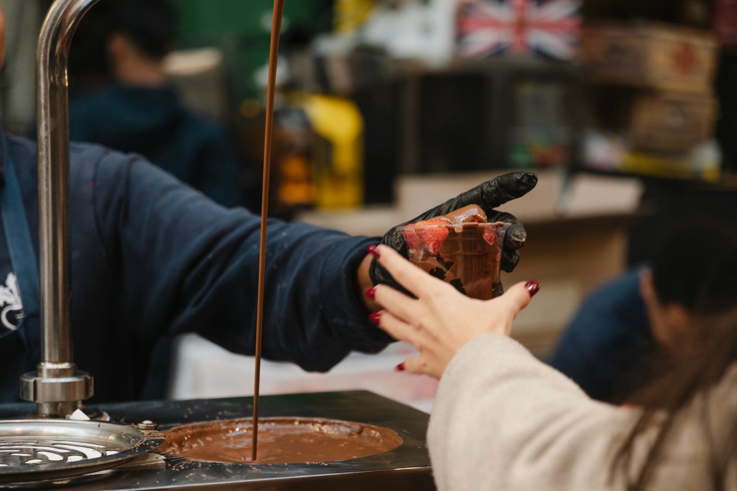 A guest receives some chocolate-covered strawberries on a bar and market food tasting tour 