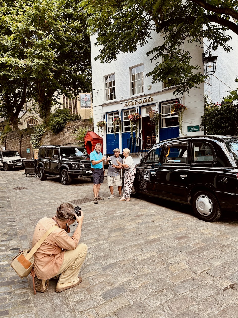 Tally Ho guests pose for their photographer outside the Grenadier Pub in London