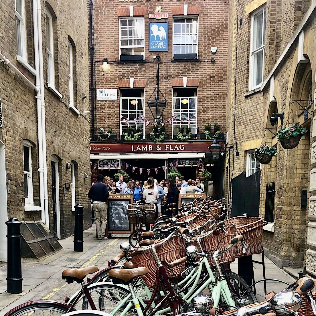 Vintage bicycles lined up outside of the Lamb and Flag pub in Covent Garden with guests enjoying a pint of ale 